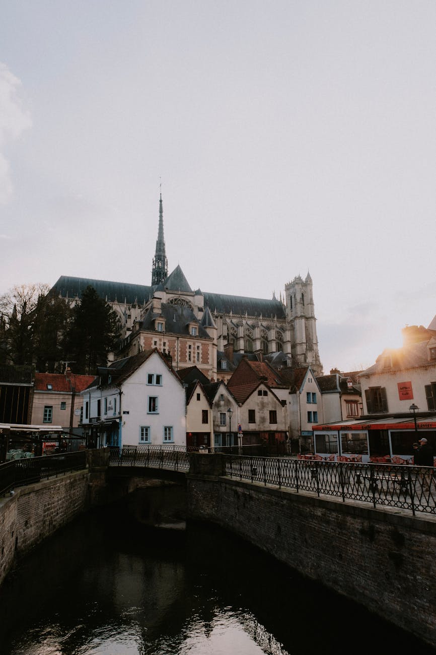 Cathédrale Notre-Dame d'Amiens dominant les maisons en bord de Somme au coucher du soleil