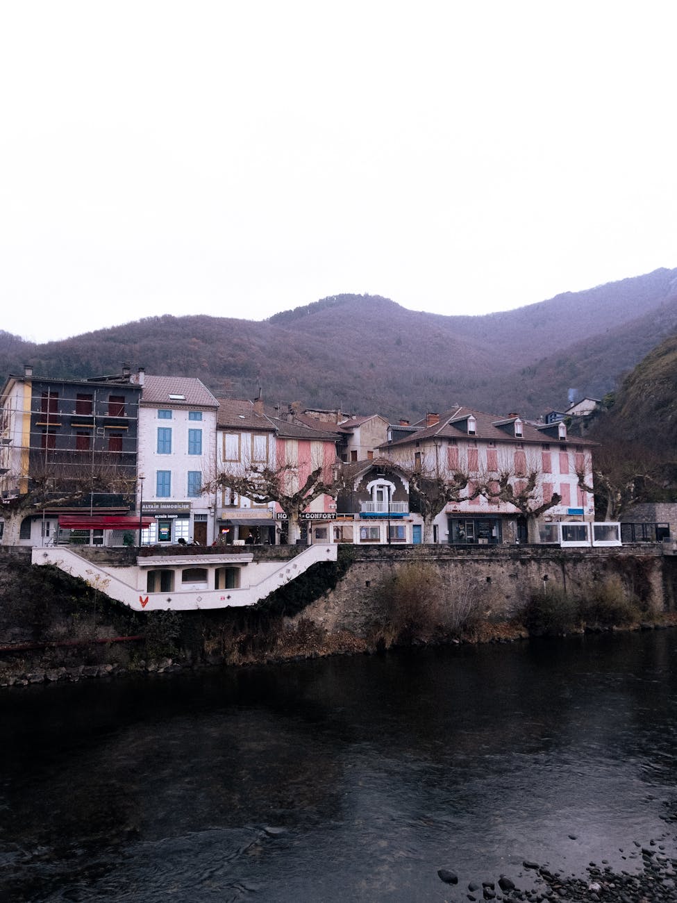 Vue des maisons colorées du village de Niaux blotti contre la montagne ariégeoise