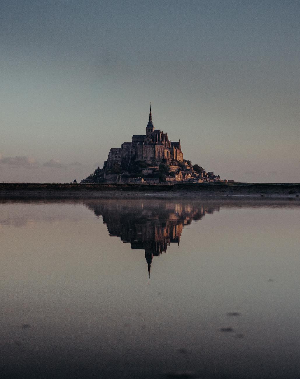 Mont-Saint-Michel se reflétant dans l'eau au crépuscule