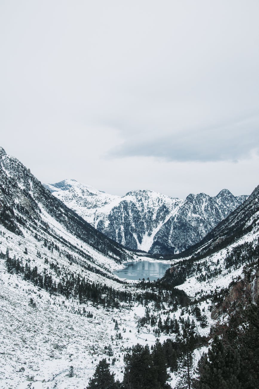 Montagnes enneigées entourant un lac gelé en hiver
