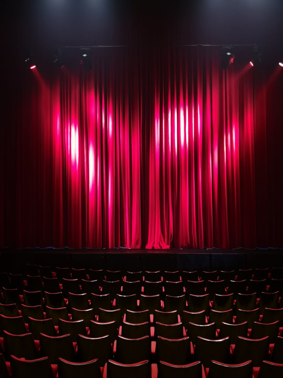 Rideau rouge de théâtre dans une salle vide