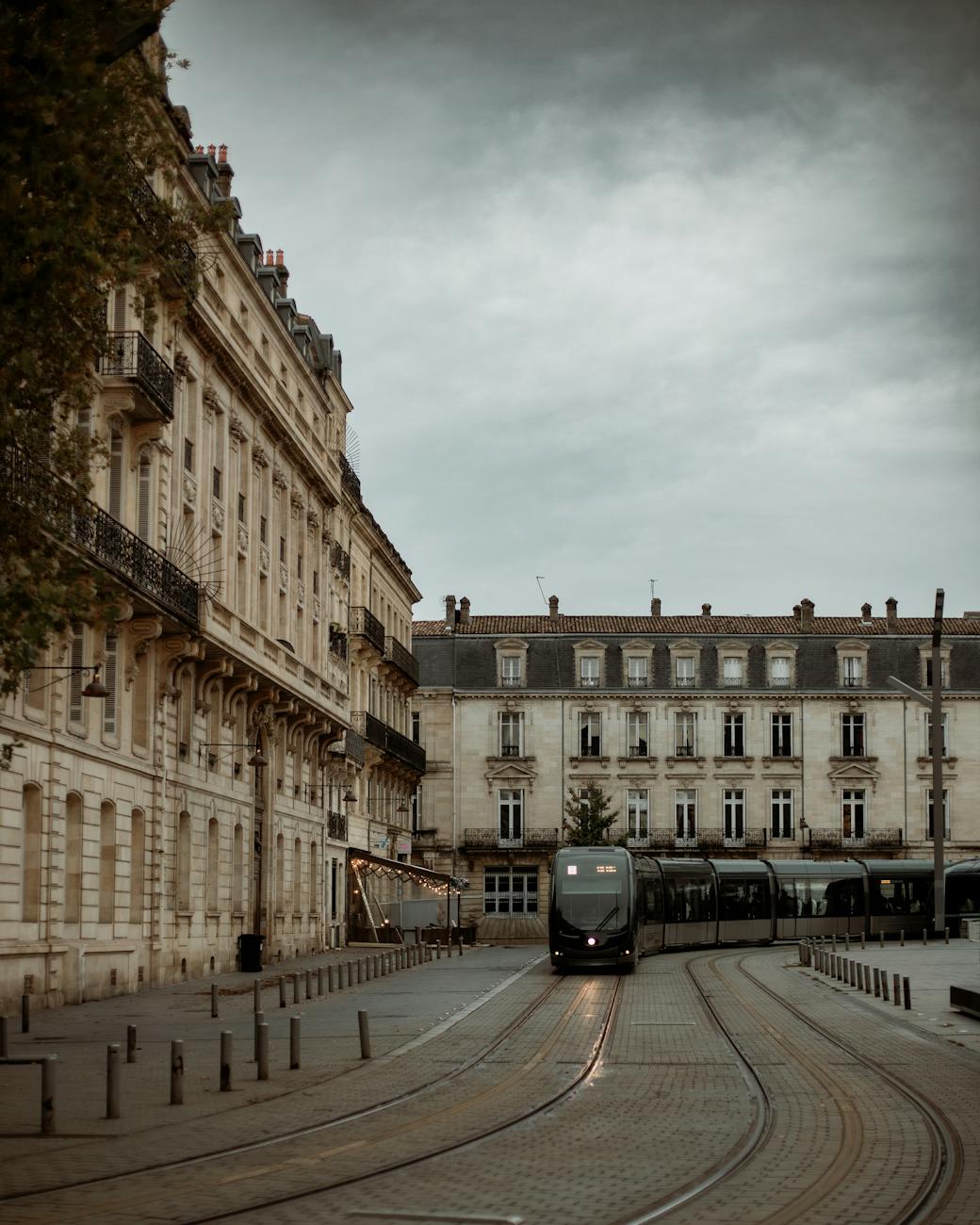 Tram glissant dans une rue historique de Bordeaux au crépuscule