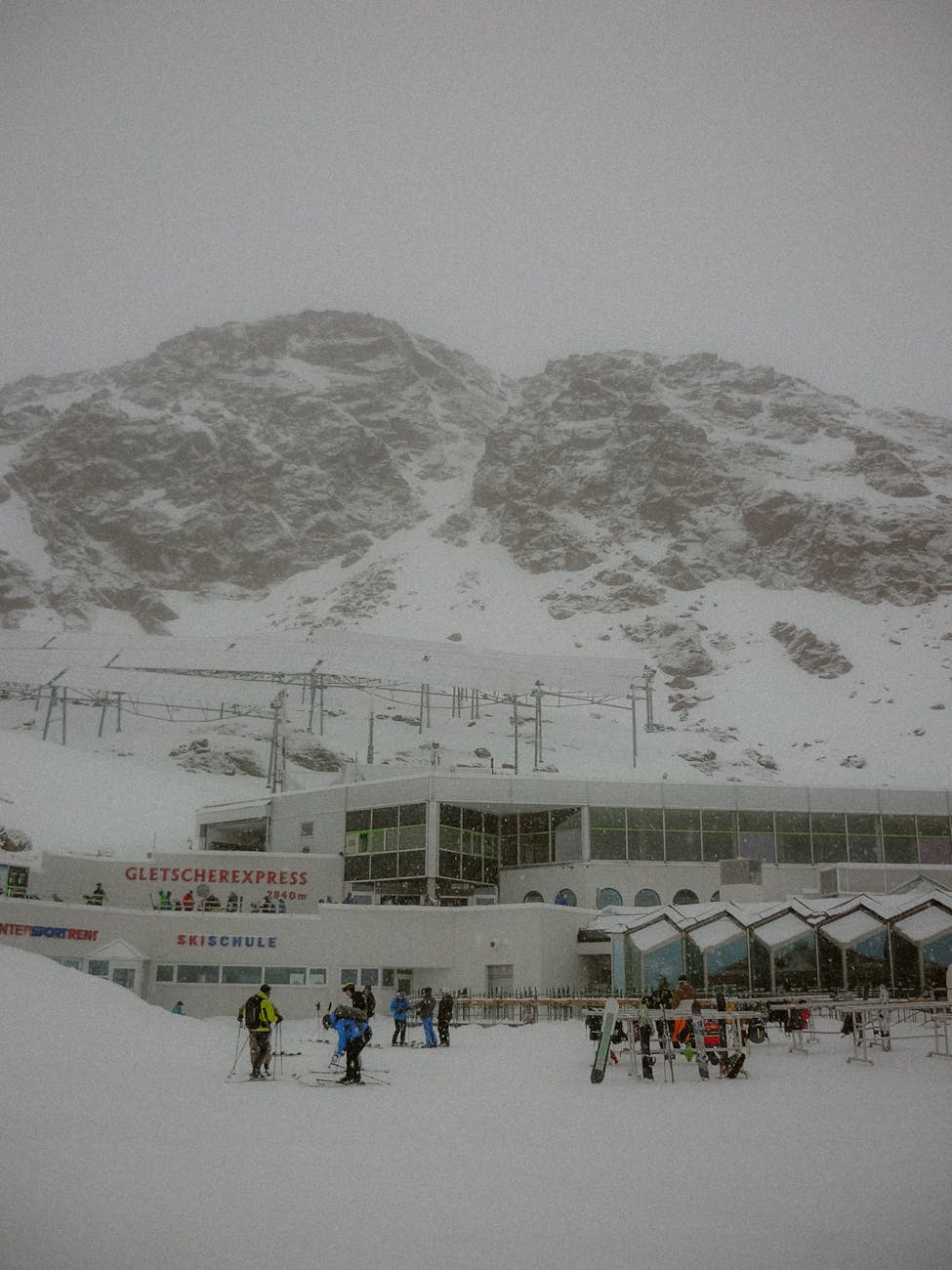 Skieurs et télésiège sur un domaine alpin enneigé