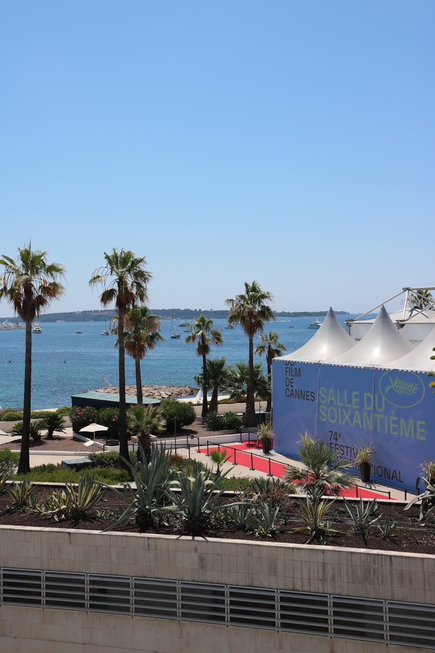 Tentes du Festival de Cannes avec mer et palmiers en arrière-plan