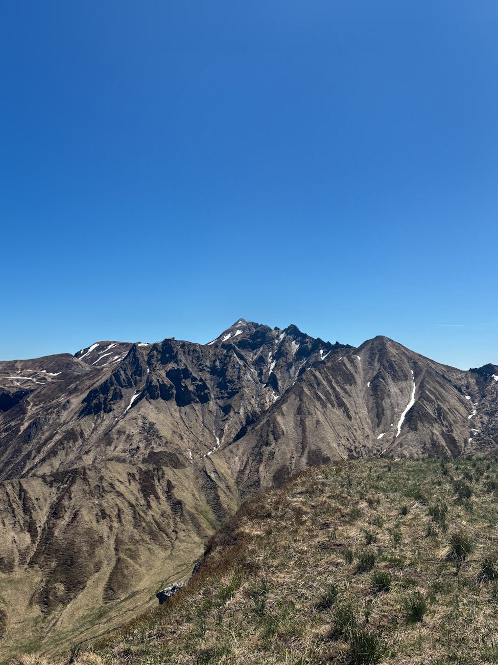 Vue panoramique d'un massif montagneux sous un ciel bleu clair