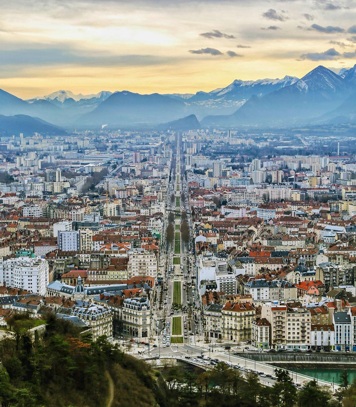 Vue aérienne d'une cité alpine au crépuscule avec montagnes en arrière-plan
