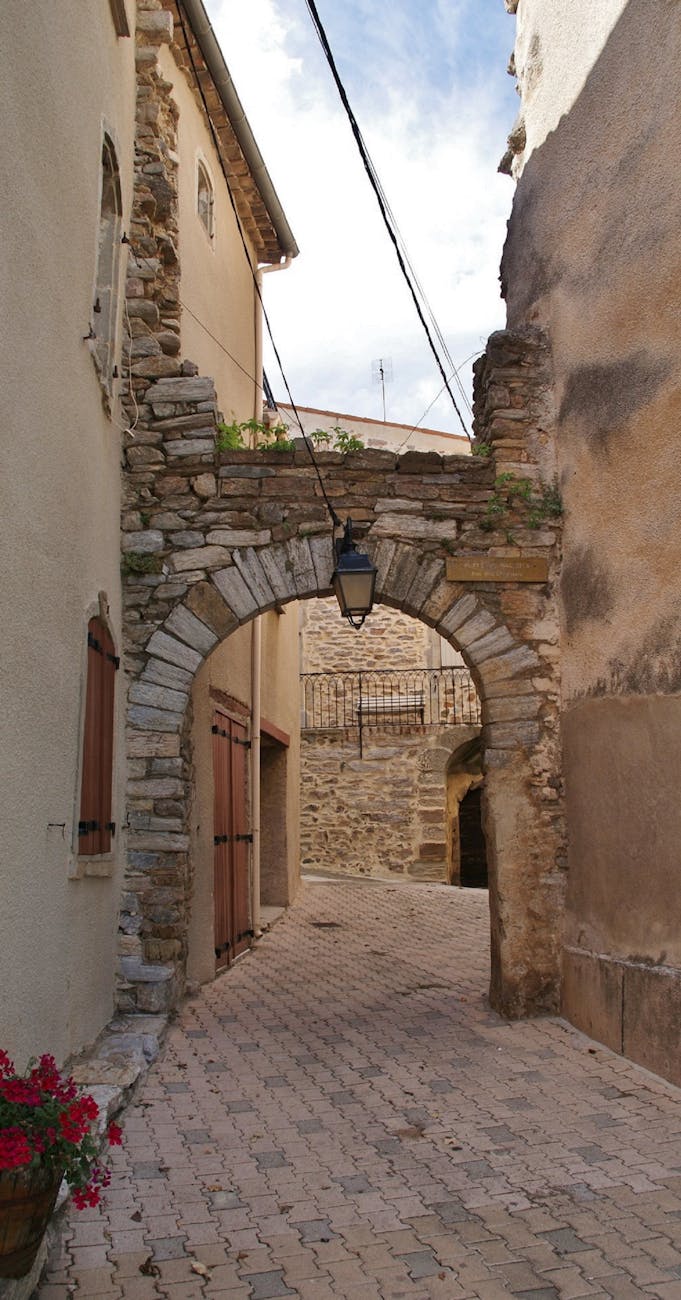 Ruelle en pierre avec arche dans un village français historique