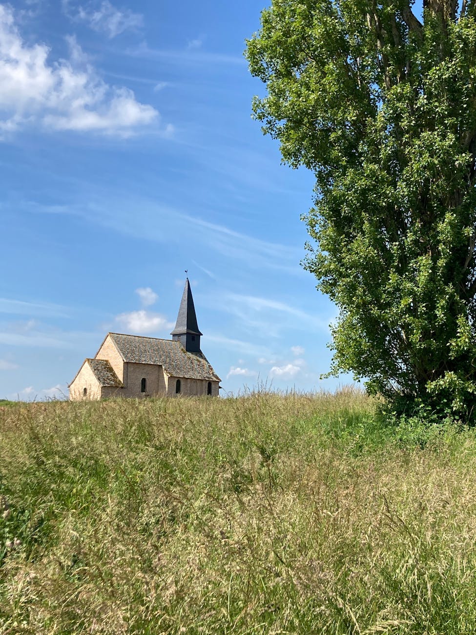 Église rurale en pierre dans la campagne française avec ciel bleu