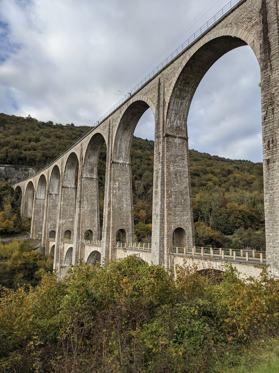 Viaduc de Cize-Bolozon en France entouré de feuillages d'automne
