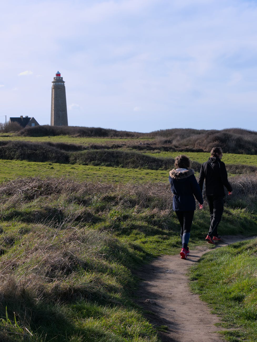 Couple sur un sentier près d'un phare en Normandie