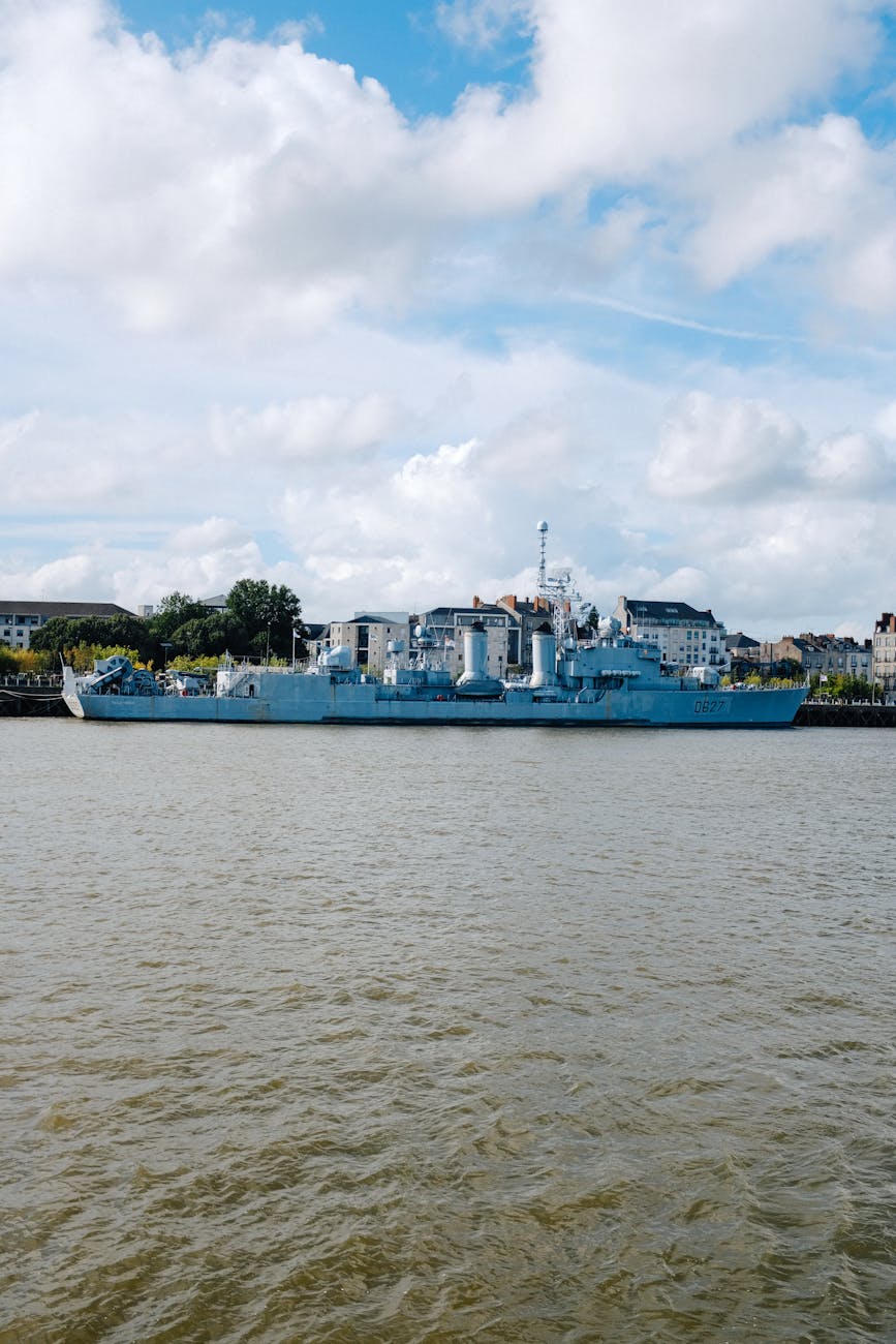 Navire militaire à quai sur un front de mer urbain