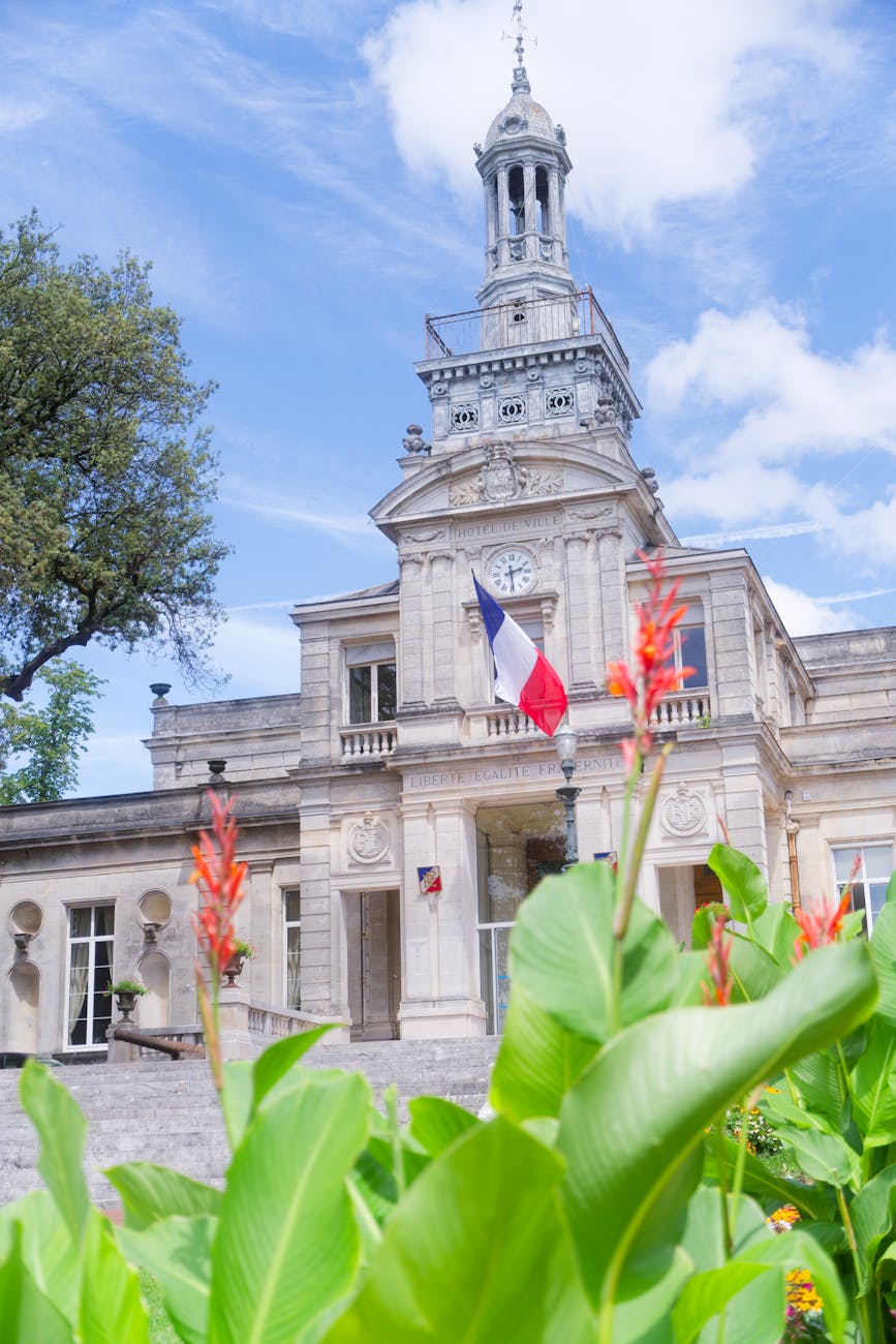 Hôtel de ville historique de Cognac avec drapeau français et jardins