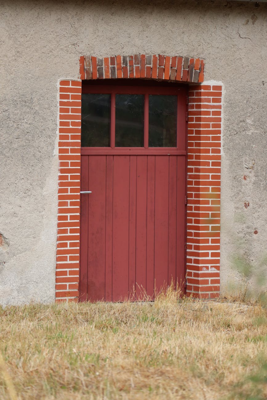 Porte en bois rouge sur un mur en pierre rustique