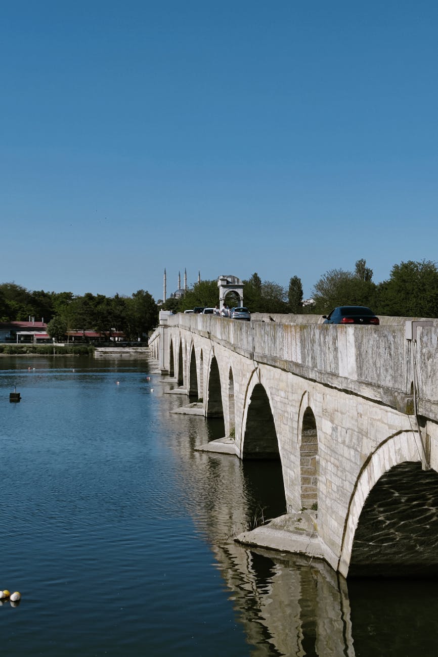 Pont en pierre arches sur une rivière paisible sous un ciel clair
