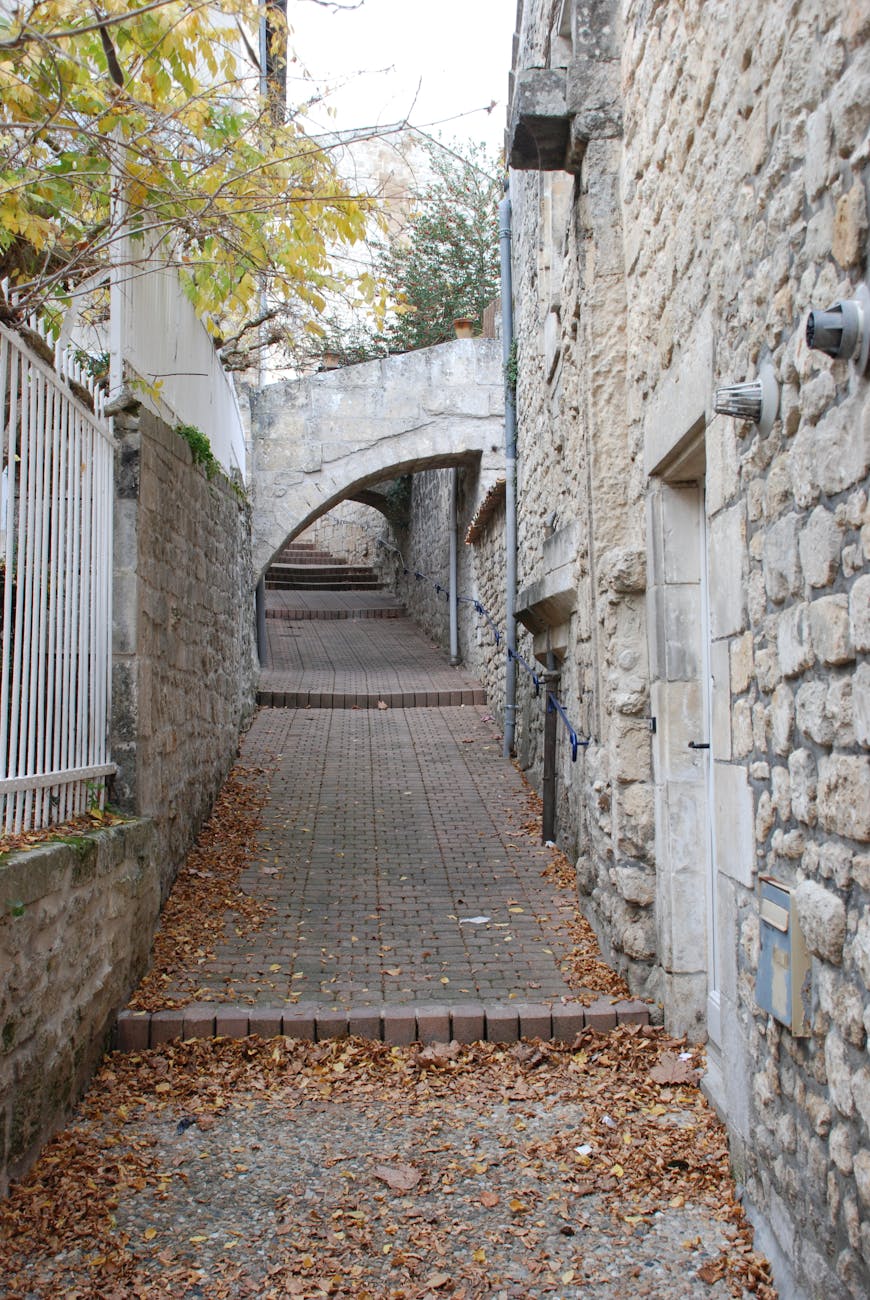 Ruelle en pierre d'un village avec feuilles d'automne, ambiance tranquille