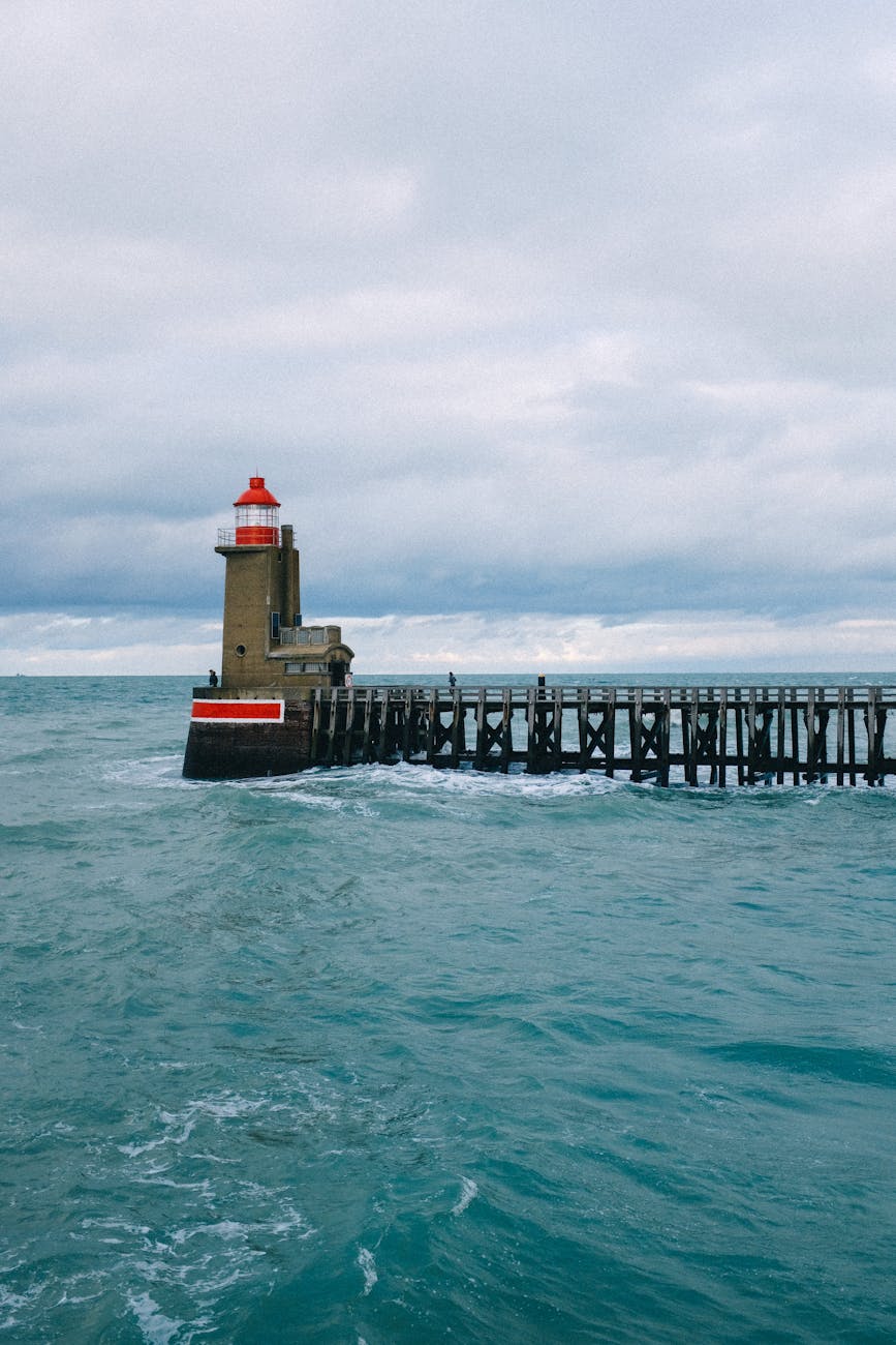 Phare en bout de jetée sous un ciel nuageux