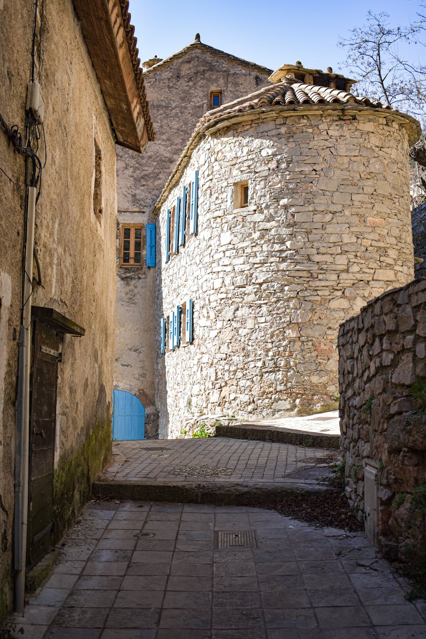 Ruelle pavée d'un village français aux volets bleus