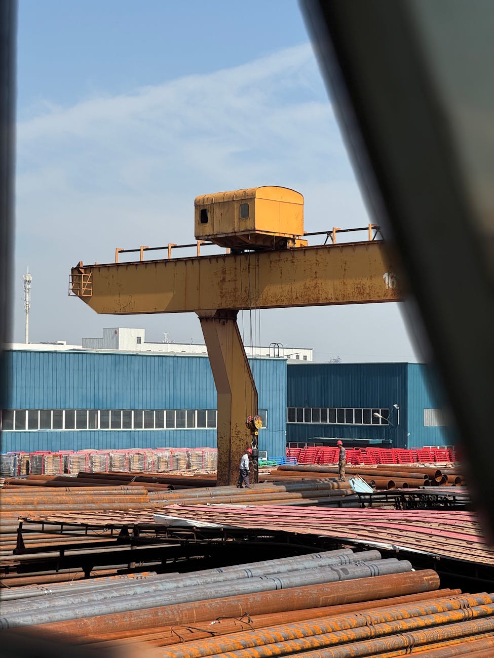 Grande grue industrielle dans une cour d'usine sidérurgique