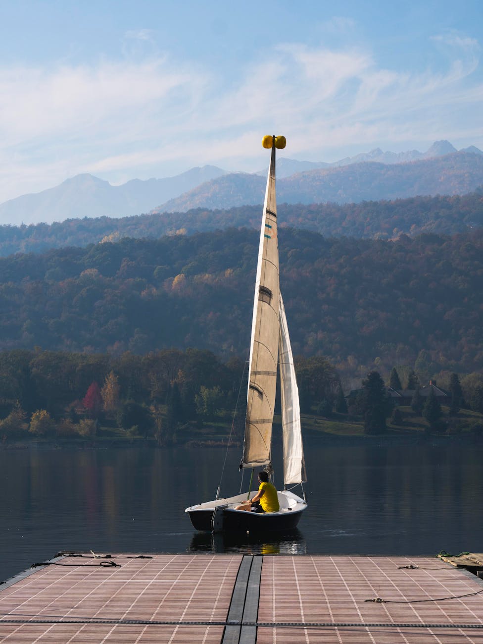 Voilier quittant un ponton de lac de montagne