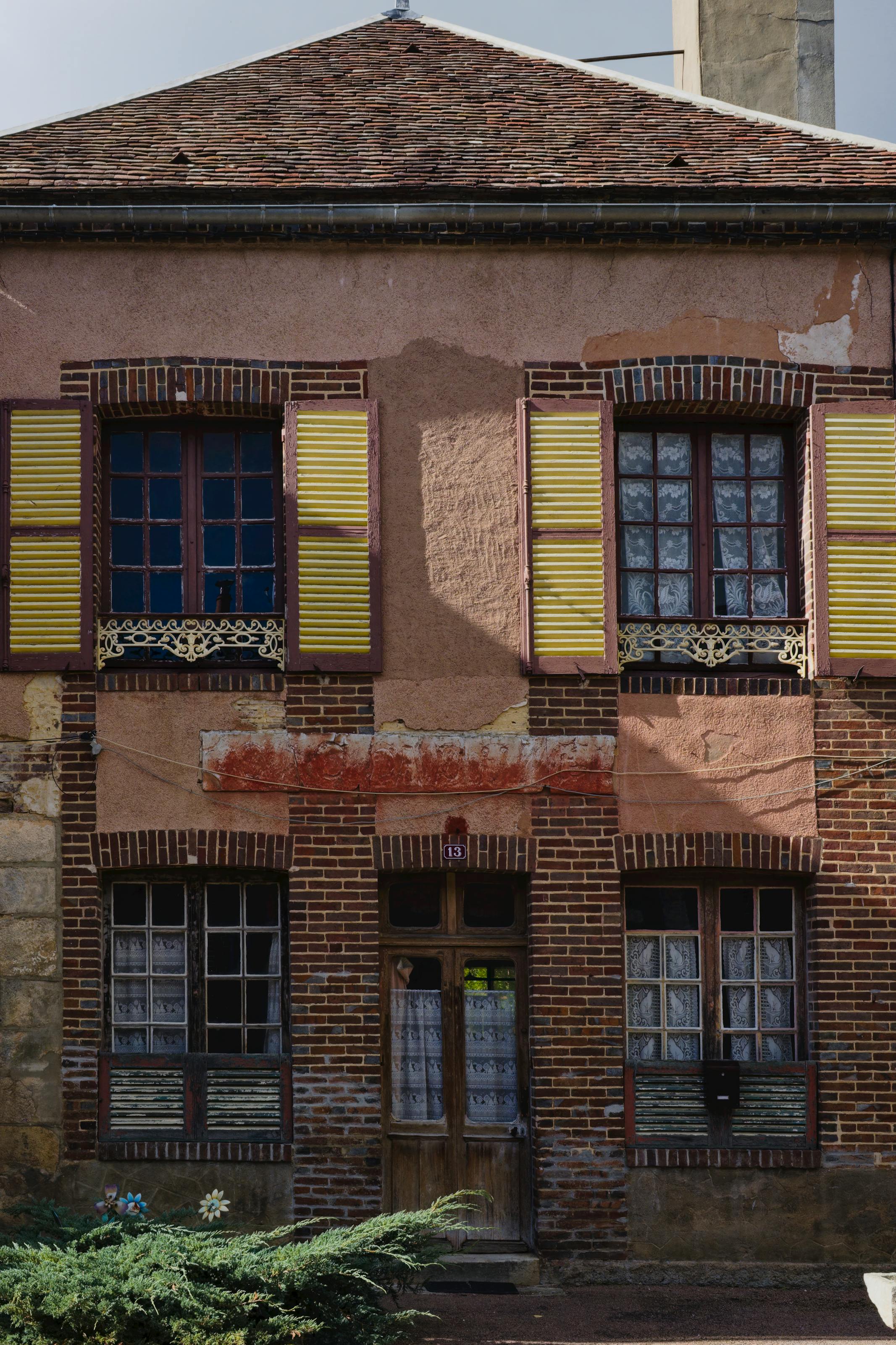 Façade d'une vieille maison avec briques et volets