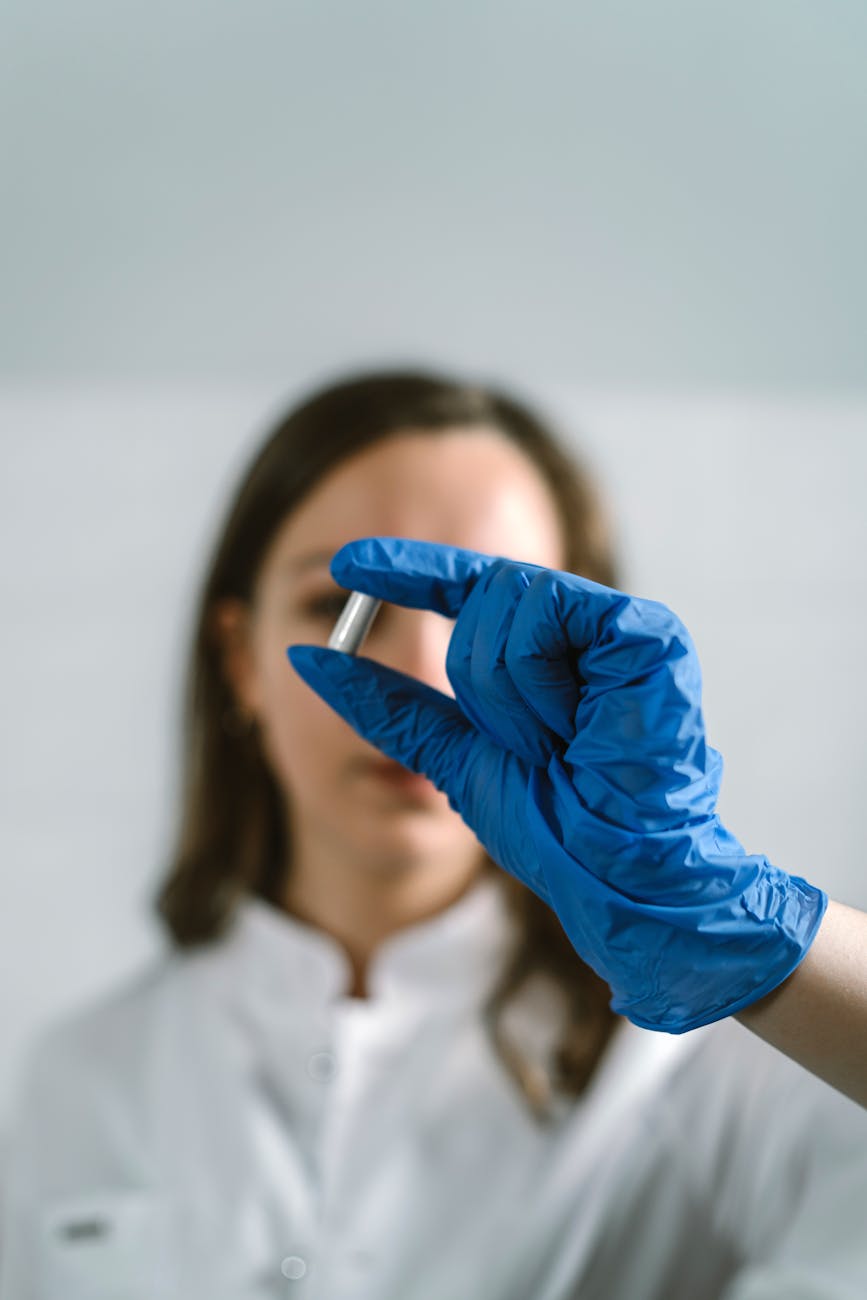 Scientifique en blouse examinant une capsule en laboratoire