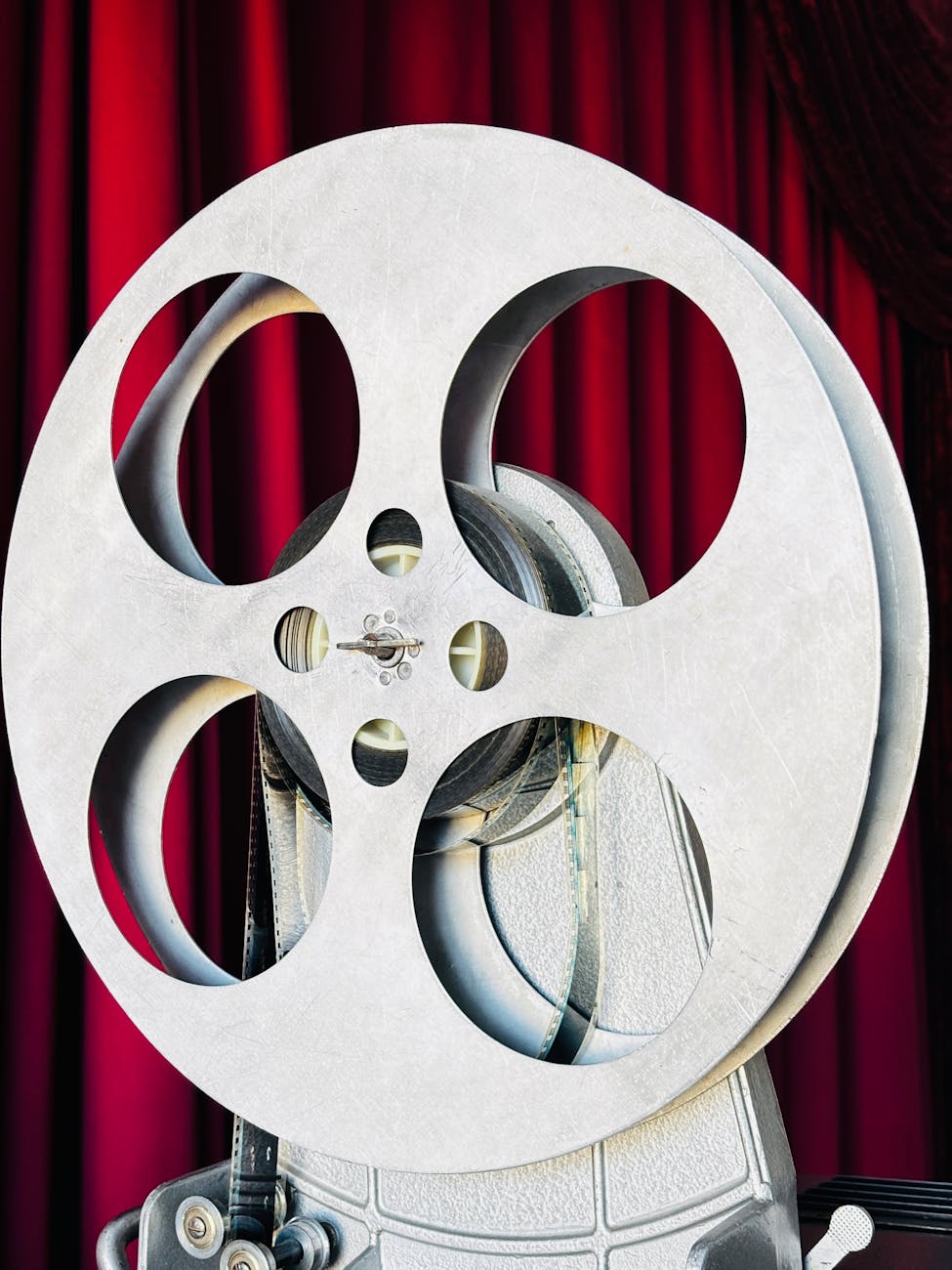 Bobine de film vintage devant un rideau de théâtre rouge