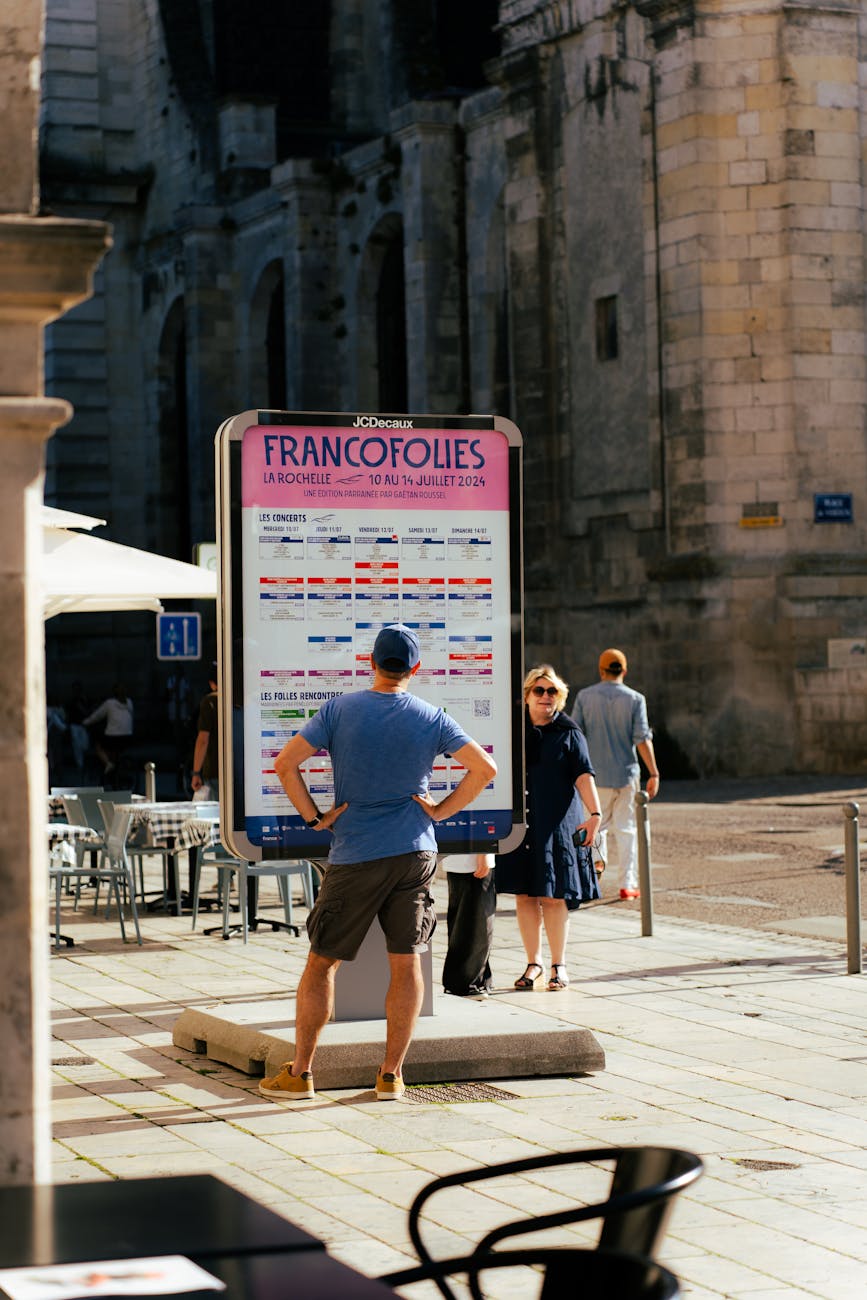 Public devant l'affiche du festival des Francofolies à La Rochelle