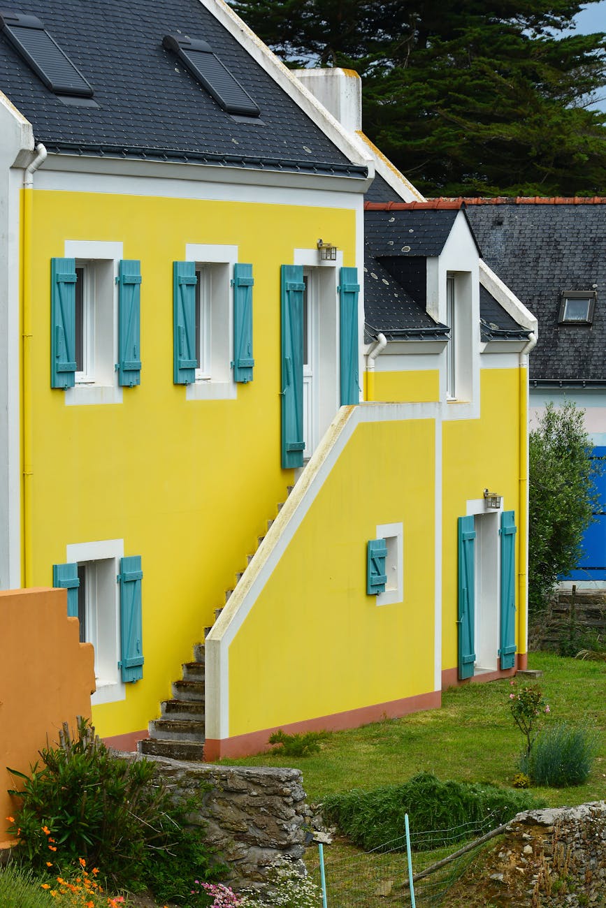 Maison jaune avec volets bleus typique de Bretagne