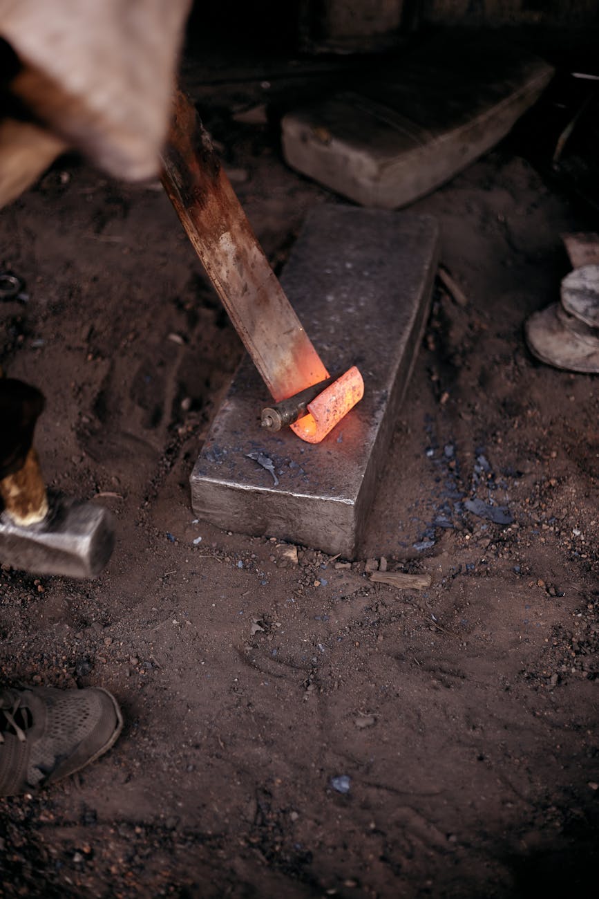 Forgeron travaillant le métal au marteau sur une enclume