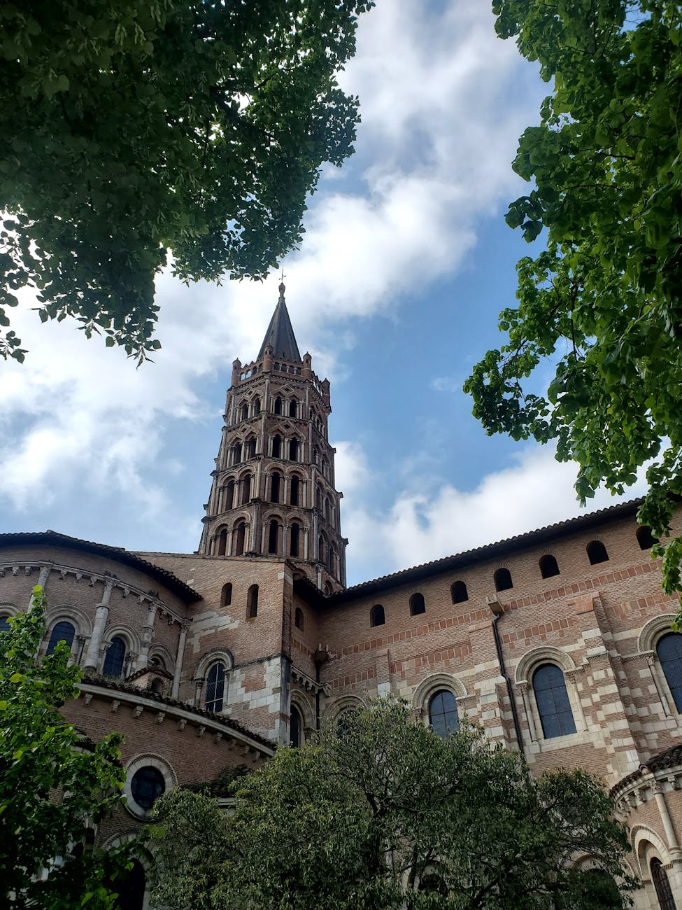 Tour de cathédrale gothique en briques contre un ciel bleu