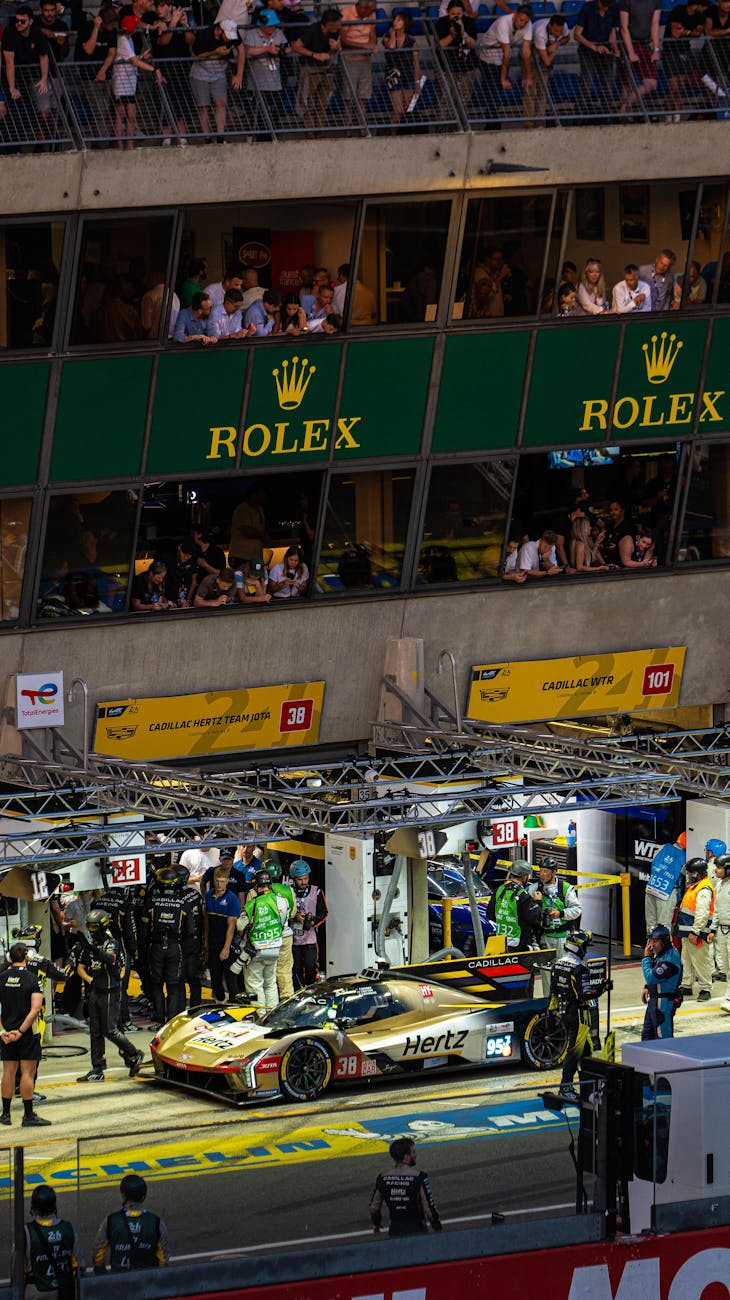 Stand de course aux 24 Heures du Mans, mécaniciens en action de nuit