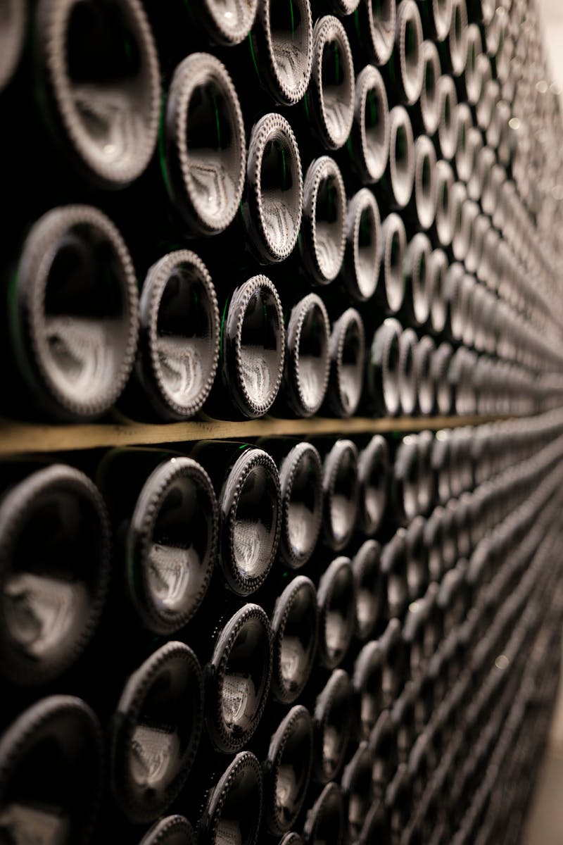 Bouteilles de vin couchées en rangs symétriques dans une cave