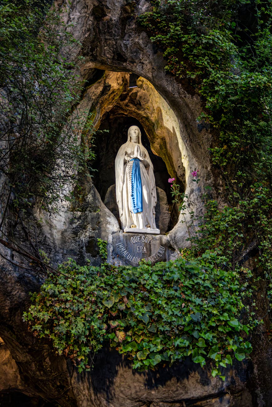 Statue illuminée de la Vierge Marie dans une grotte
