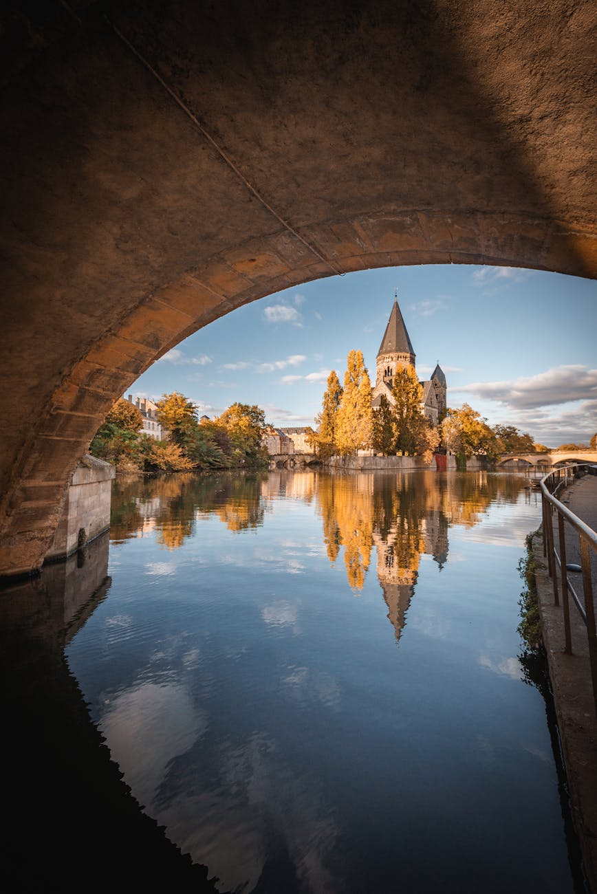 Église historique se reflétant dans l'eau sous un pont à Metz