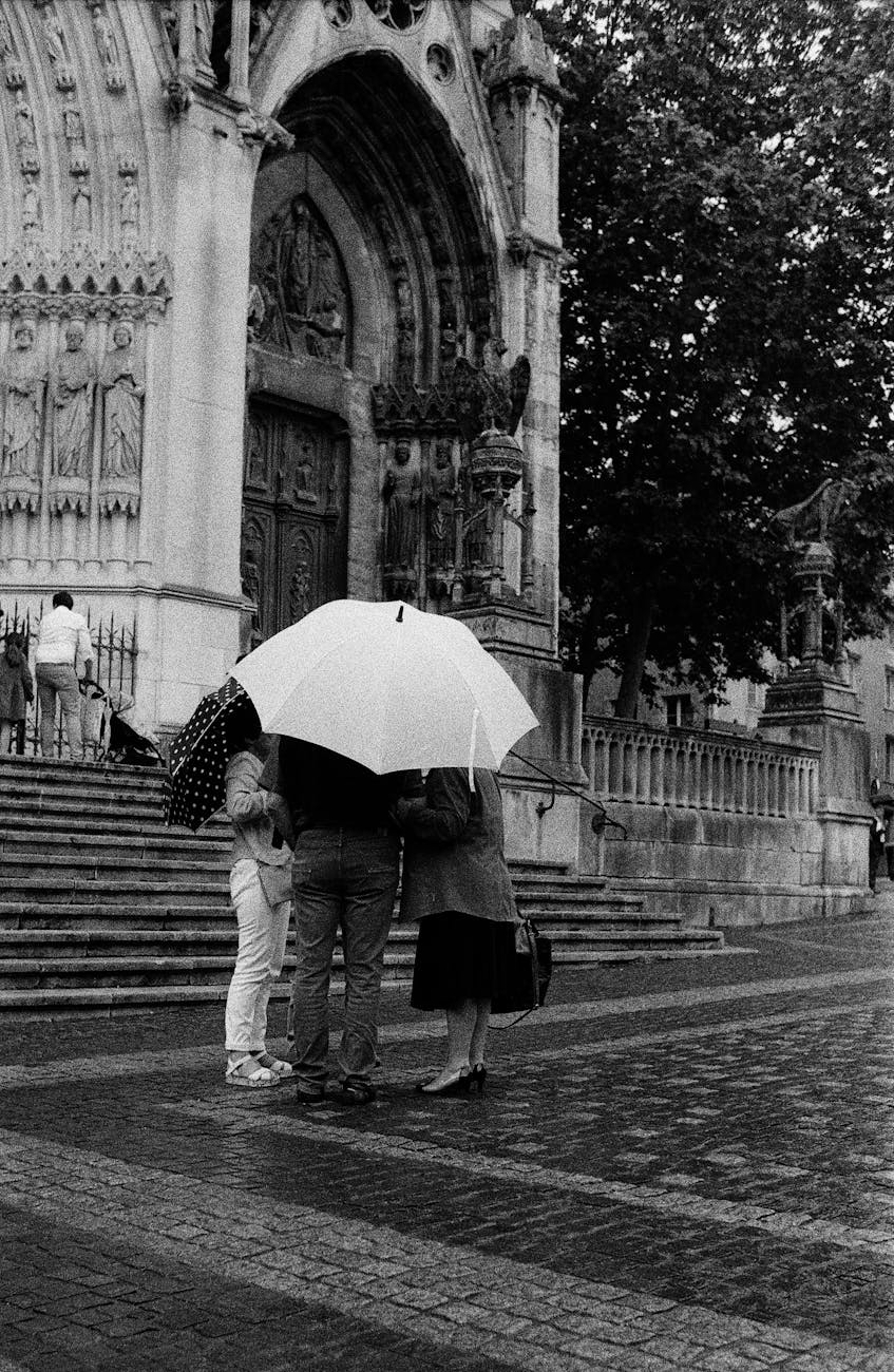 Groupe de personnes sous des parapluies près de la cathédrale de Nancy