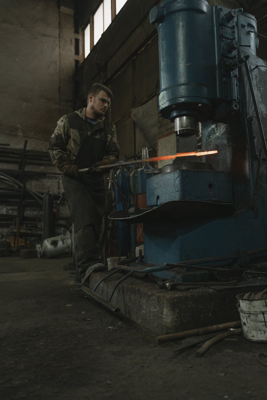 Pièce de métal chauffée travaillée sous une presse hydraulique industrielle