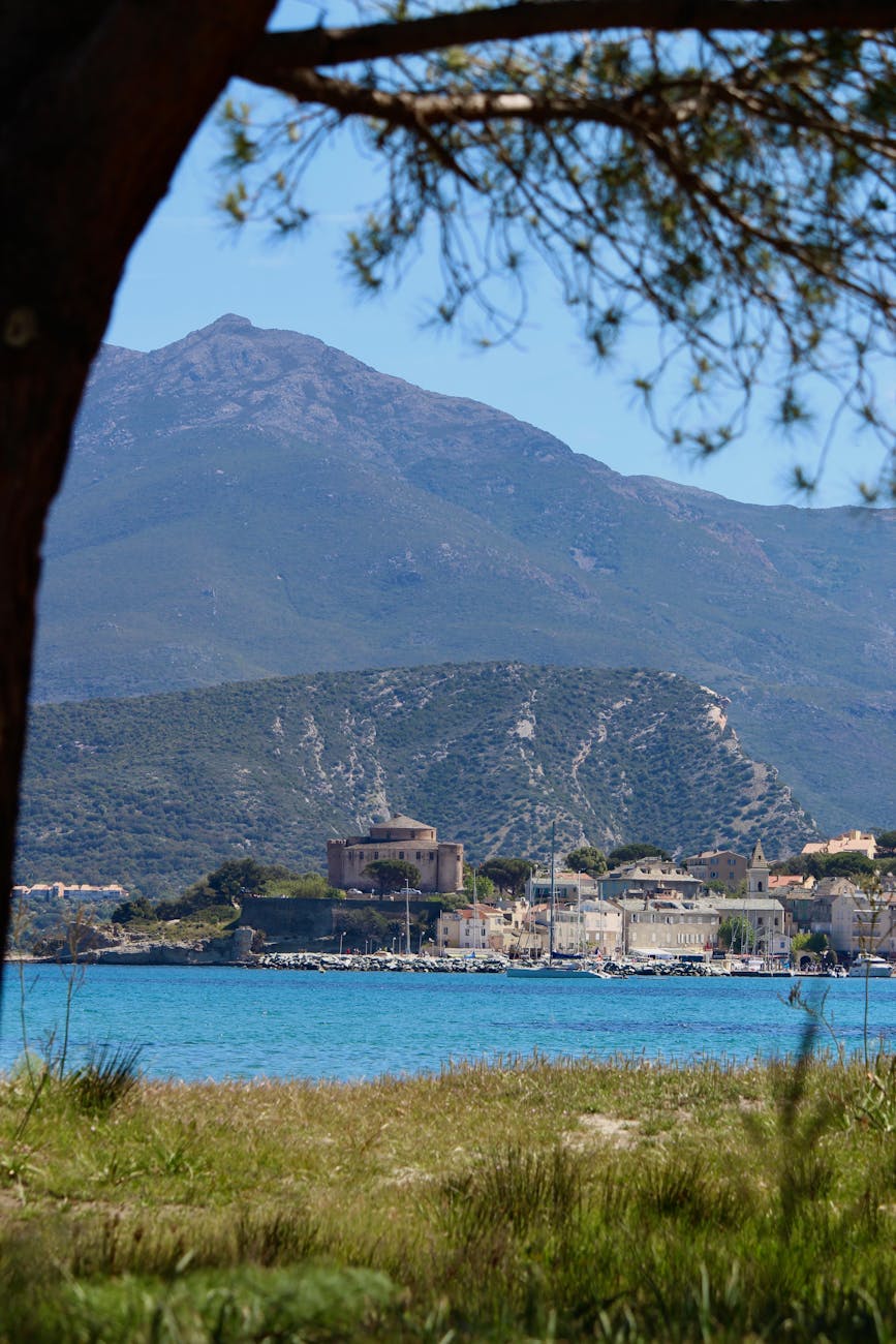 Village corse au bord de mer avec montagnes en arrière-plan