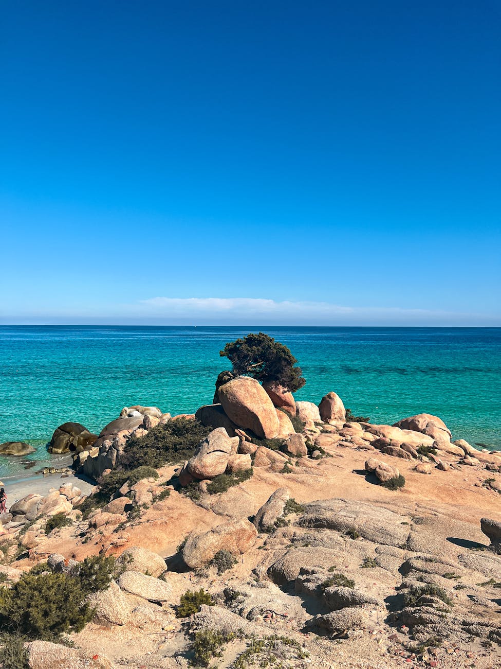Plage rocheuse aux eaux turquoise sous un ciel bleu