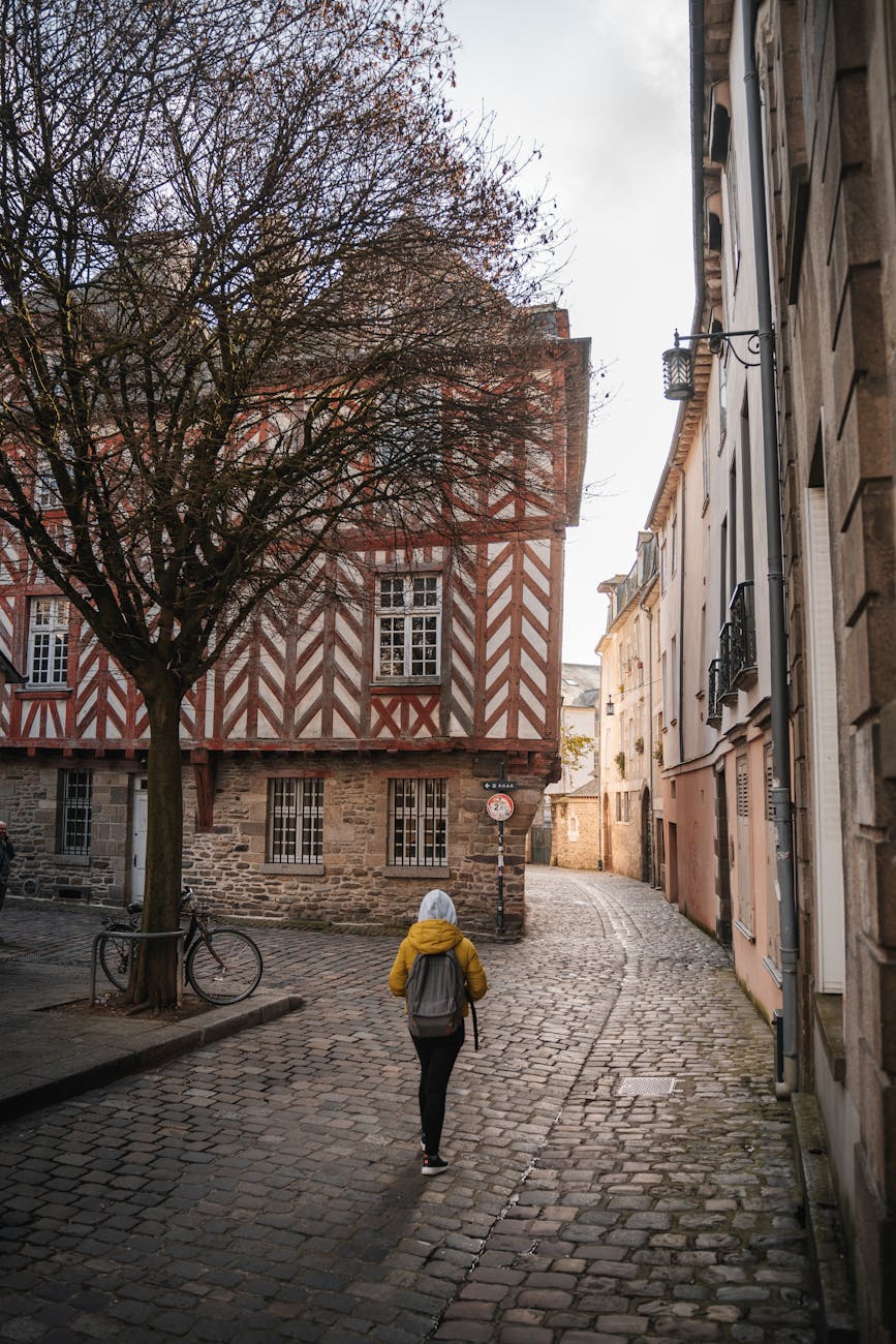 Femme marchant entre les immeubles d'une rue de Rennes