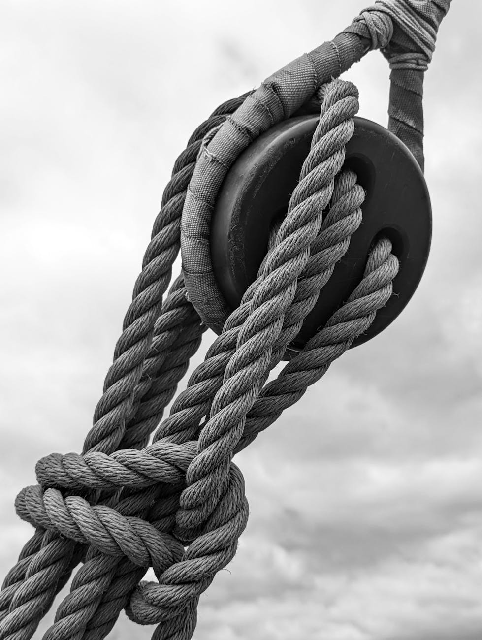 Cordages marins et poulie sur un voilier sous un ciel nuageux, force nautique