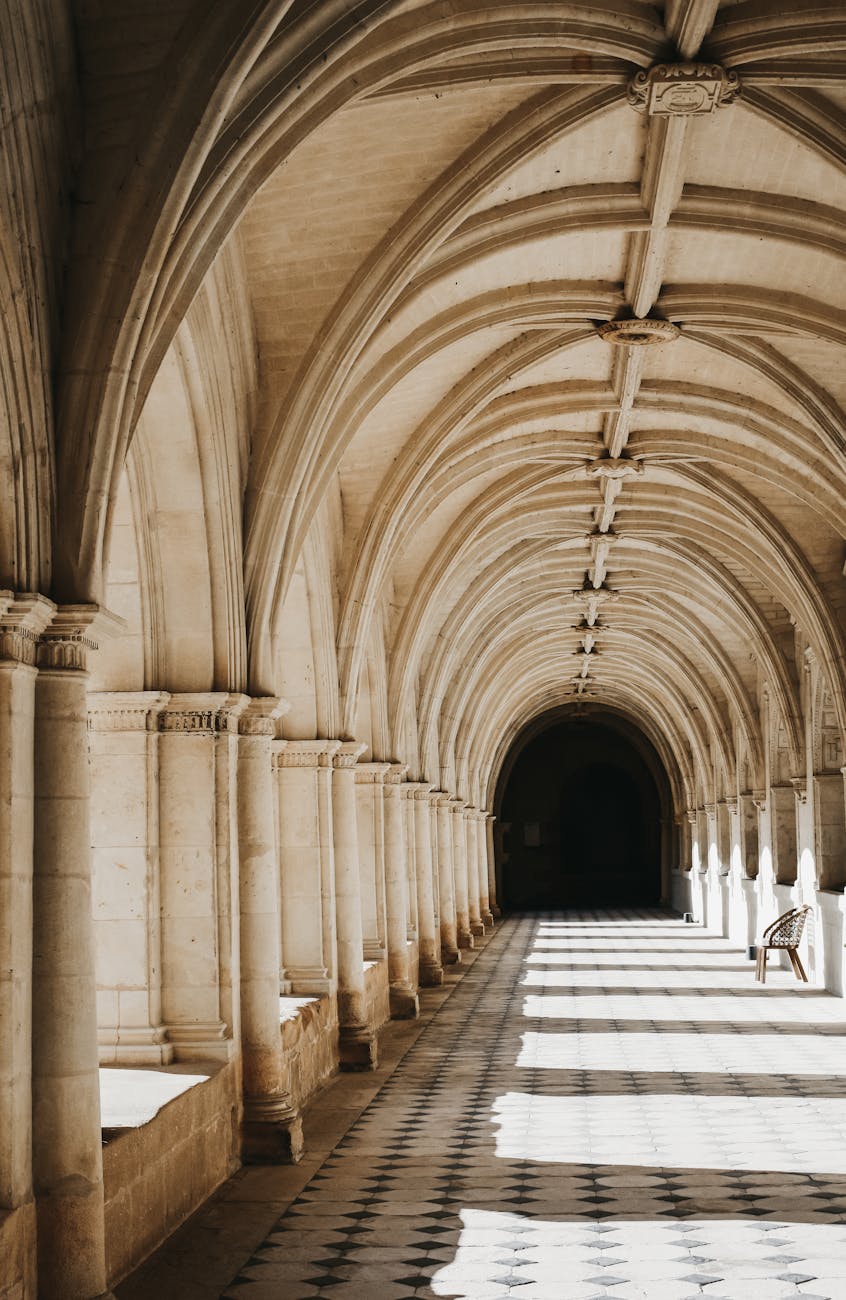 Cloître d'abbaye française avec arches et colonnes baignées de soleil