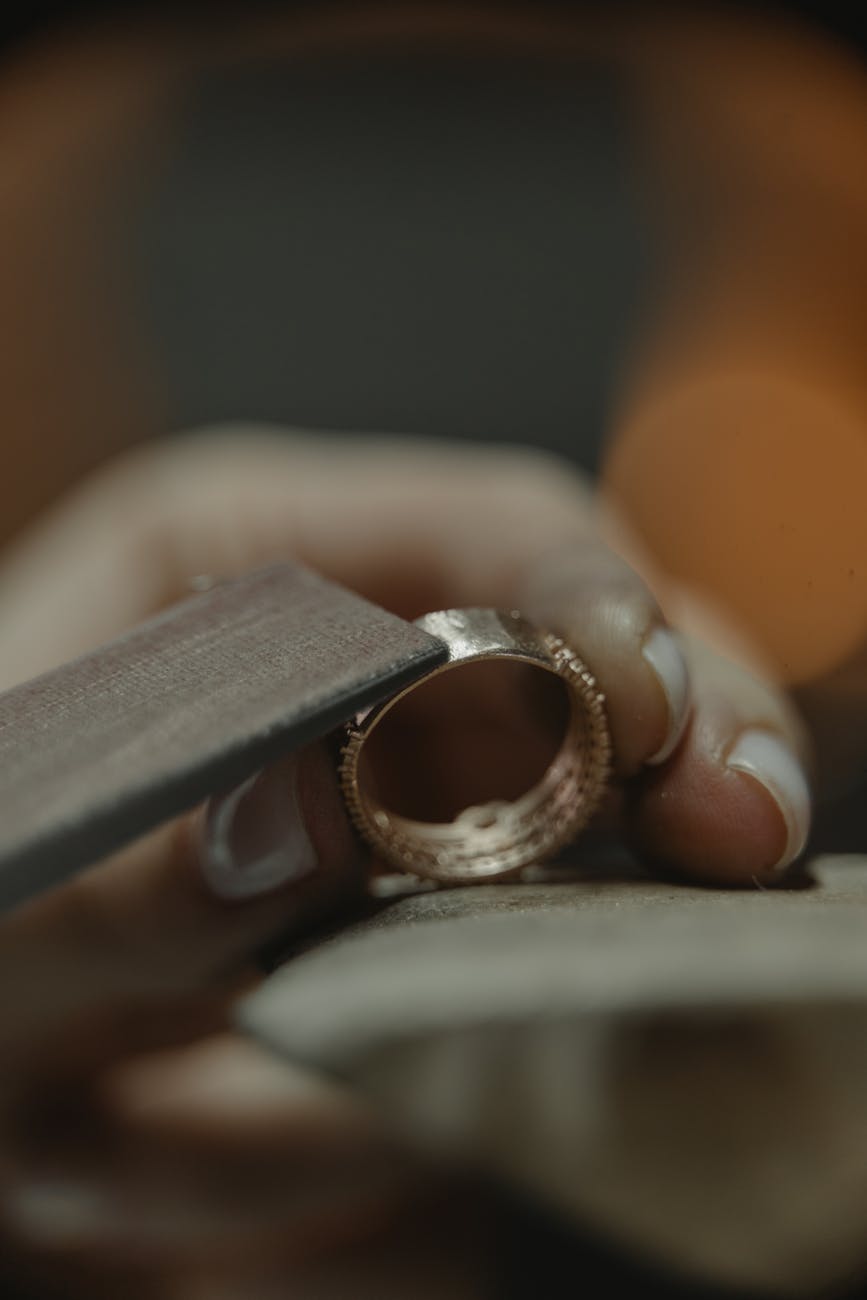 Bijoutier polissant une bague en or, savoir-faire artisanal de précision