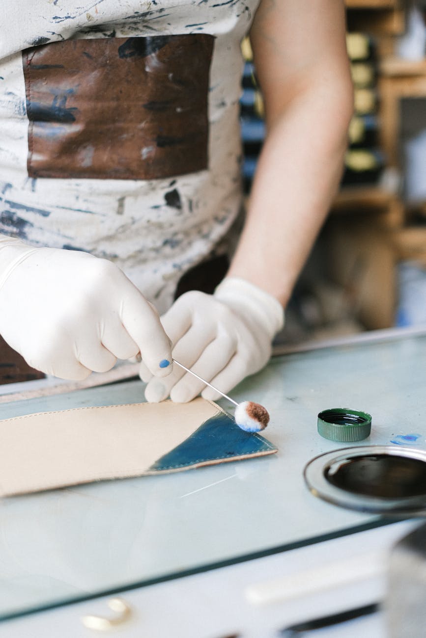 Artisan appliquant de la teinture sur du cuir avec précision