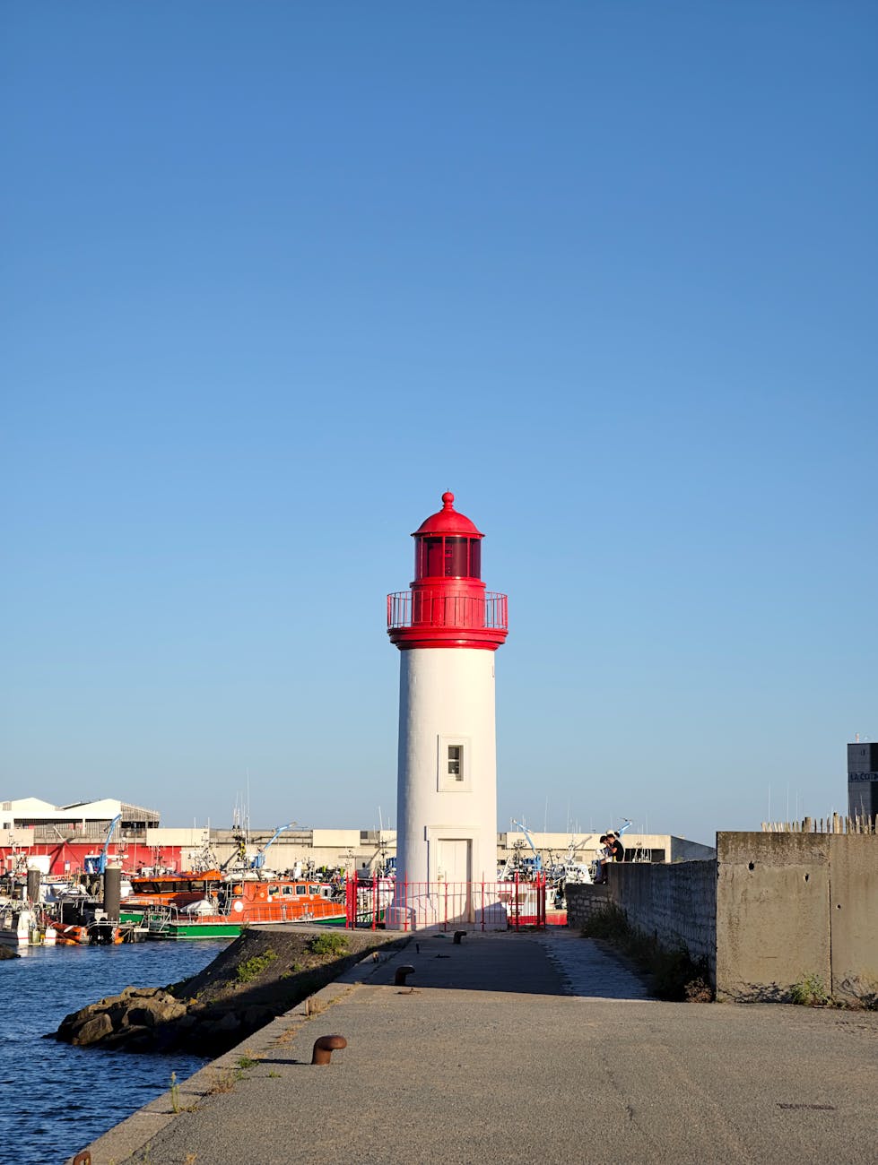Phare rouge et blanc dans le port de Saint-Pierre-d'Oléron sous un ciel bleu