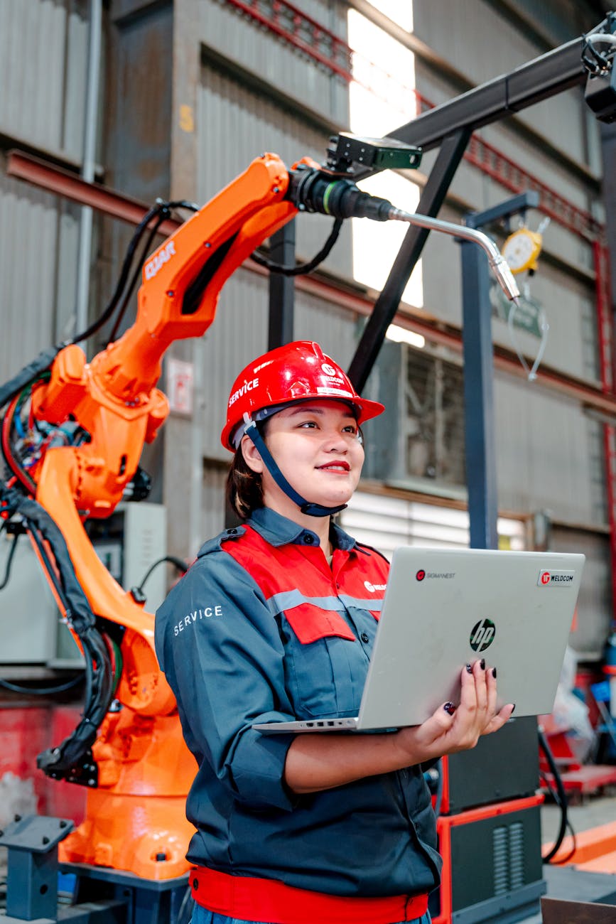 Ingénieure devant un bras robotisé en environnement industriel