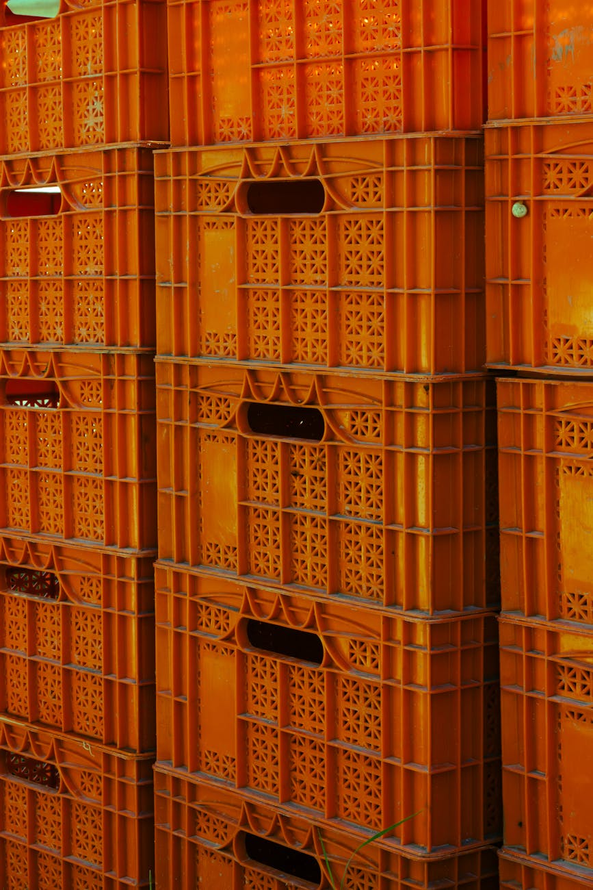 Caisses plastiques orange empilées en environnement industriel