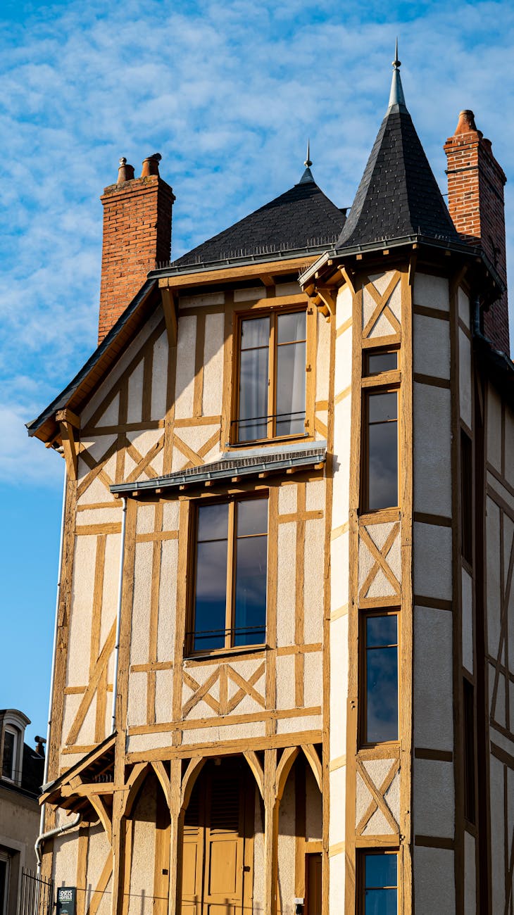 Maison à colombages aux toits pointus sous un ciel bleu