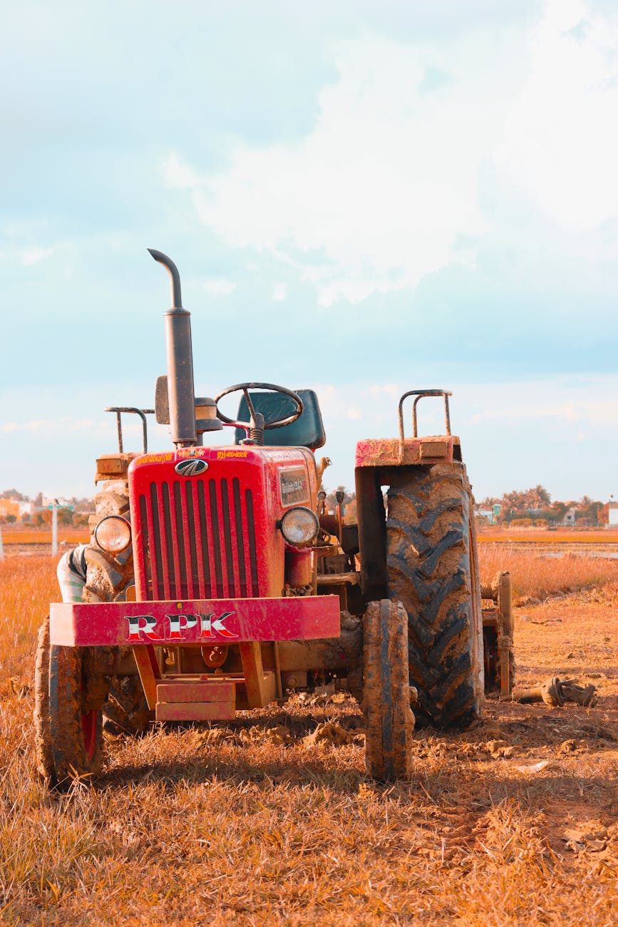 Tracteur rouge dans un champ rural ensoleillé