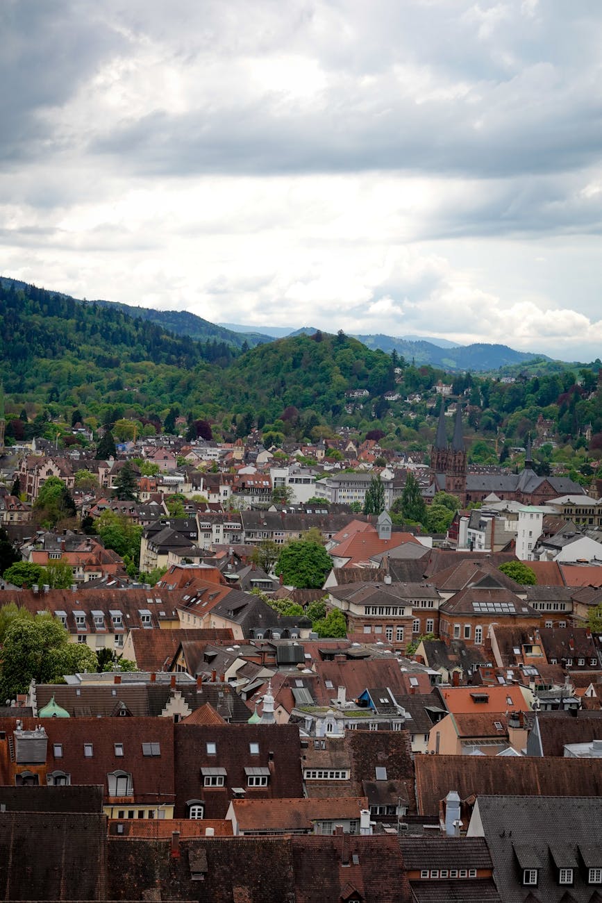 Vue aérienne d'un village européen avec collines verdoyantes