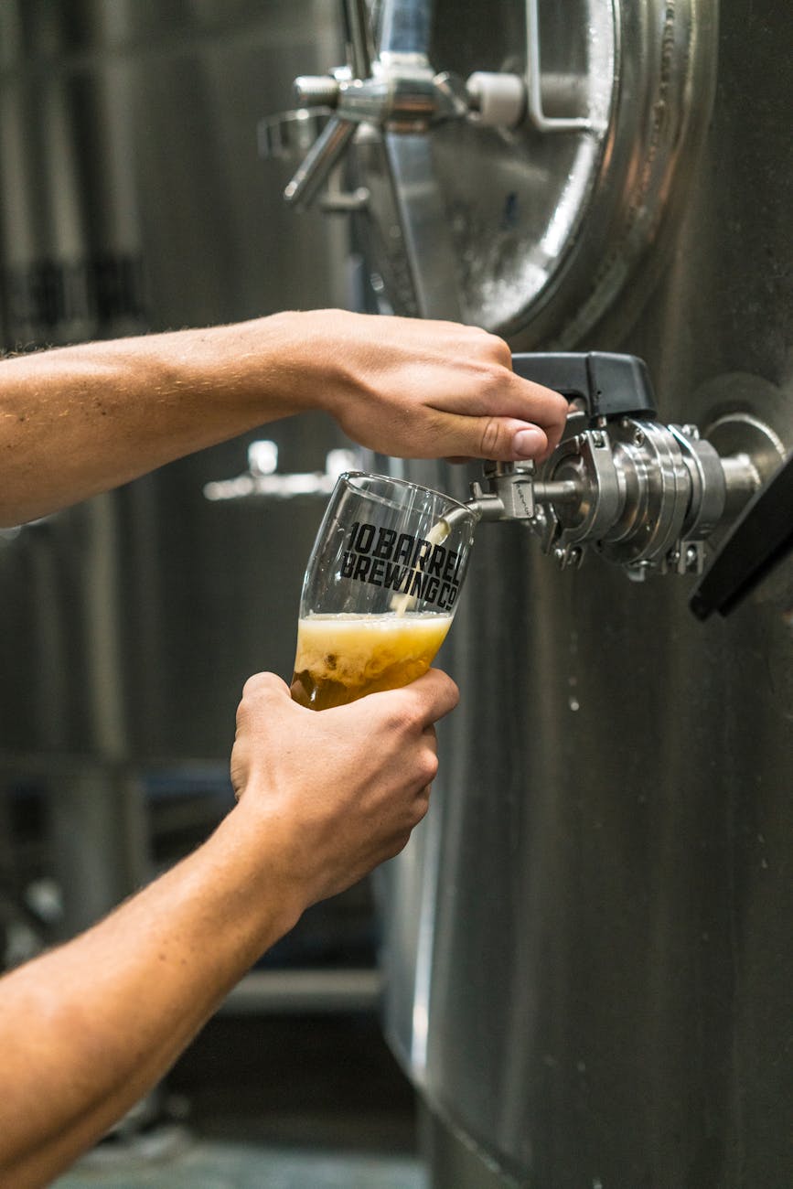 Bière coulant dans un verre depuis une cuve de brasserie